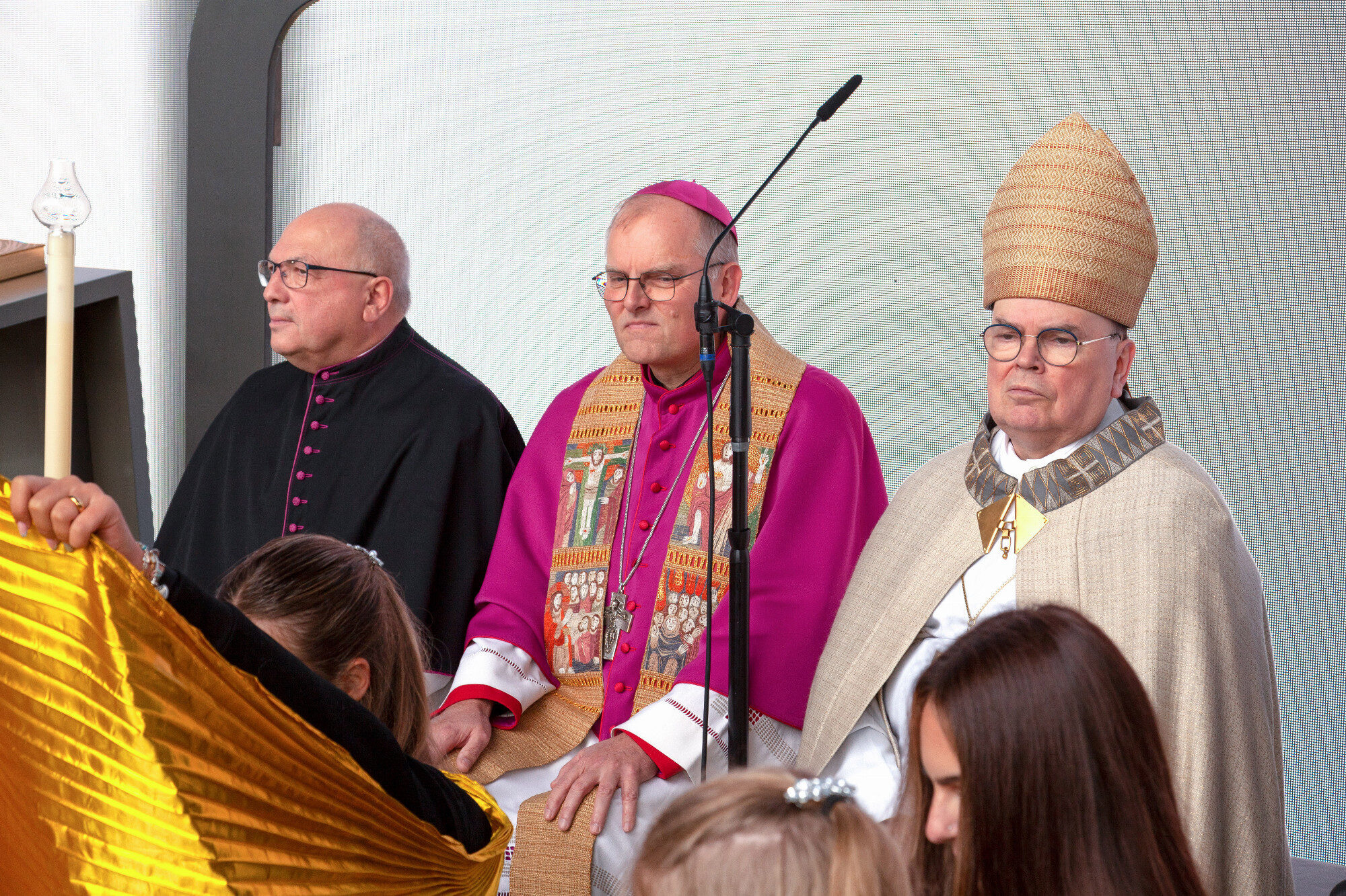 Bischof Bertram Meier mit goldener Stola auf der Bühne, WWK Arena Augsburg / Schulwerk