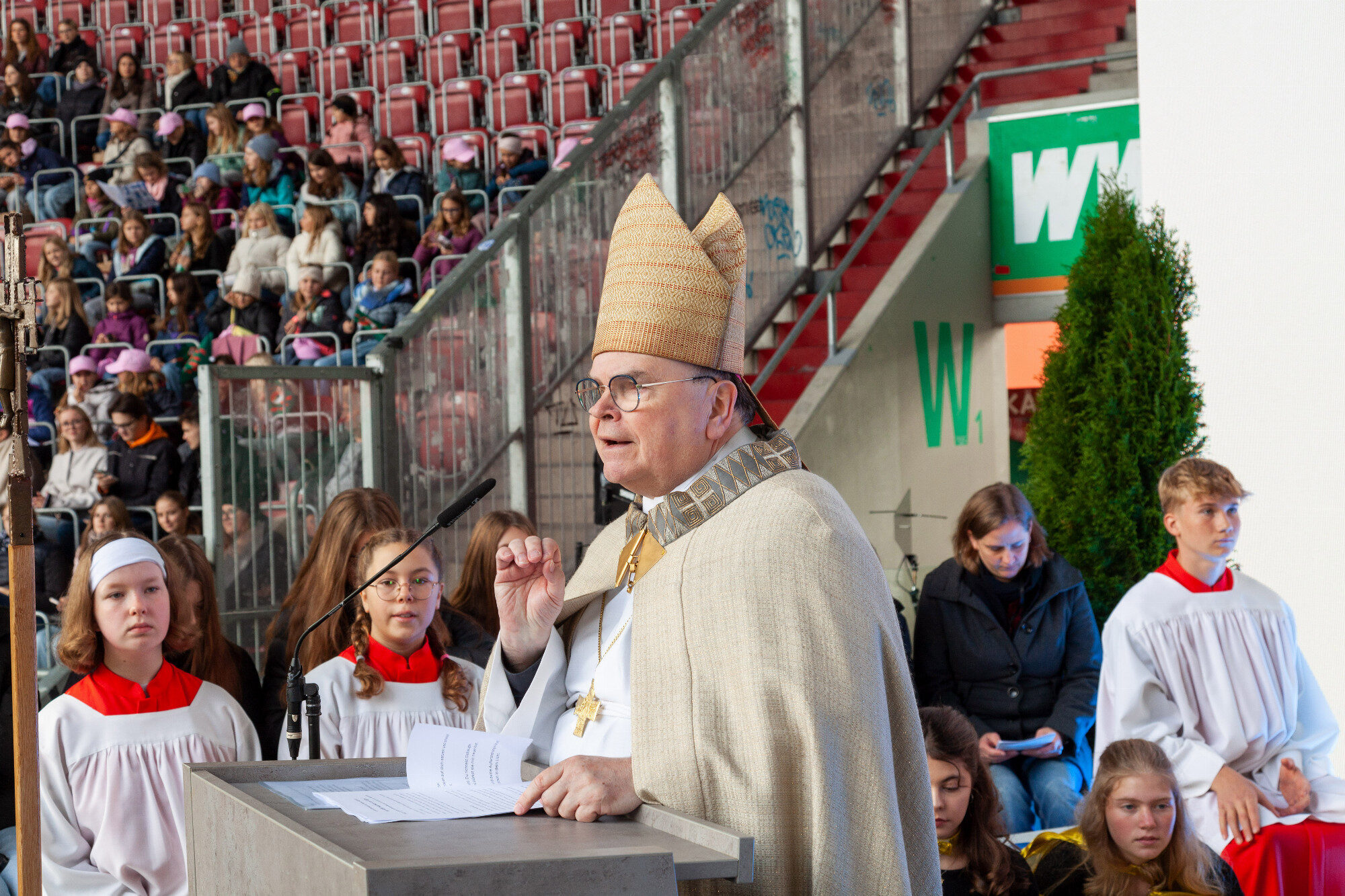 Bischof Bertram Meier am Ambo vor voller Tribüne, WWK Arena Augsburg / Schulwerk