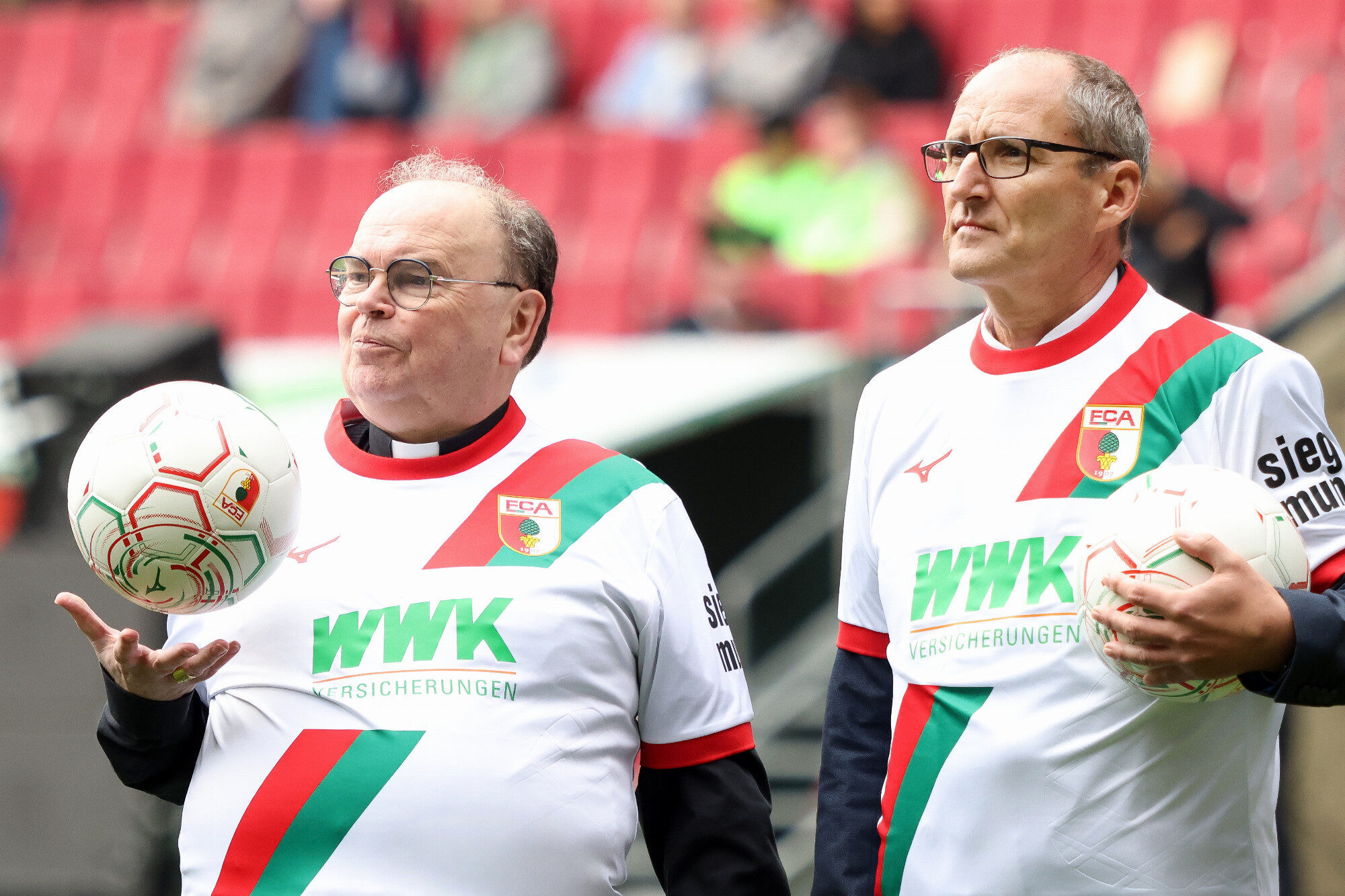 Bischof Bertram Meier balanciert den Ball auf der Hand, WWK Arena Augsburg / Schulwerk