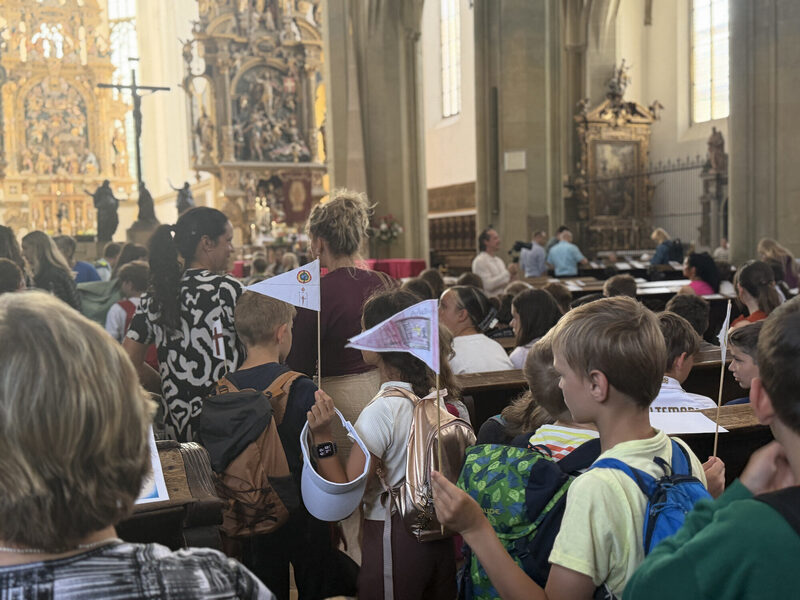 Schülerinnen und Schüler mit Fähnchen beim Pontifikalamt der Ulrichswoche in Augsburg